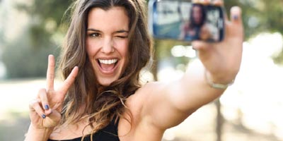 Young woman using mobile phone to profile verify with hand gesture