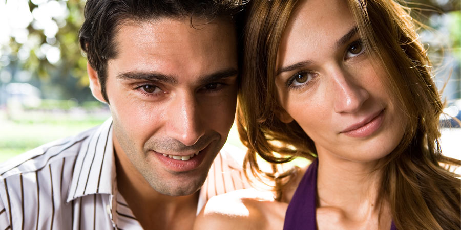 Close up of attractive couple with brown eyes and dark hair who look eerily similar to each other 